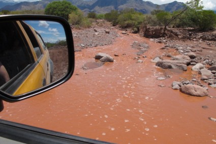 Rio invade a estrada após forte chuva.