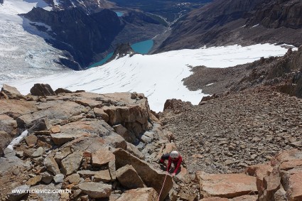 Com a Laguna Sucia abaixo, Silvia supera o trecho mais difícil da escalada do Mojon Rojo, um quarto grau com muitas pedras soltas. Foto de Waldemar Niclevicz.