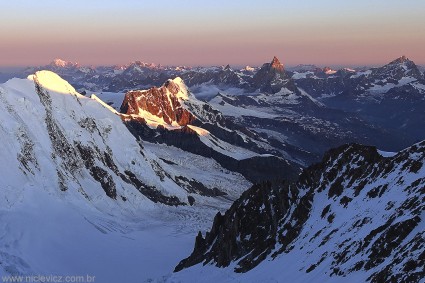 Amanhecer visto do Monte Rosa (4.634m), à direta pontiagudo o Matterhorn (4.478m), bem à esquerda ao fundo o Mont Blanc (4.807m). Foto de Waldemar Niclevicz.